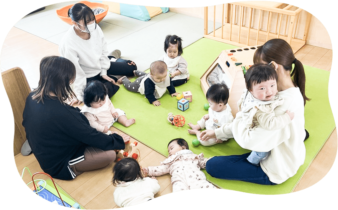 保育士と集団で遊ぶ子供たち